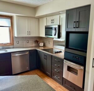 Two-tone kitchen remodel in Fargo, ND featuring light upper cabinets and dark lower cabinets, modern hardware, and refreshed finishes—highlighting the Fast, Affordable, Beautiful results of the Kitchen Refresh process.