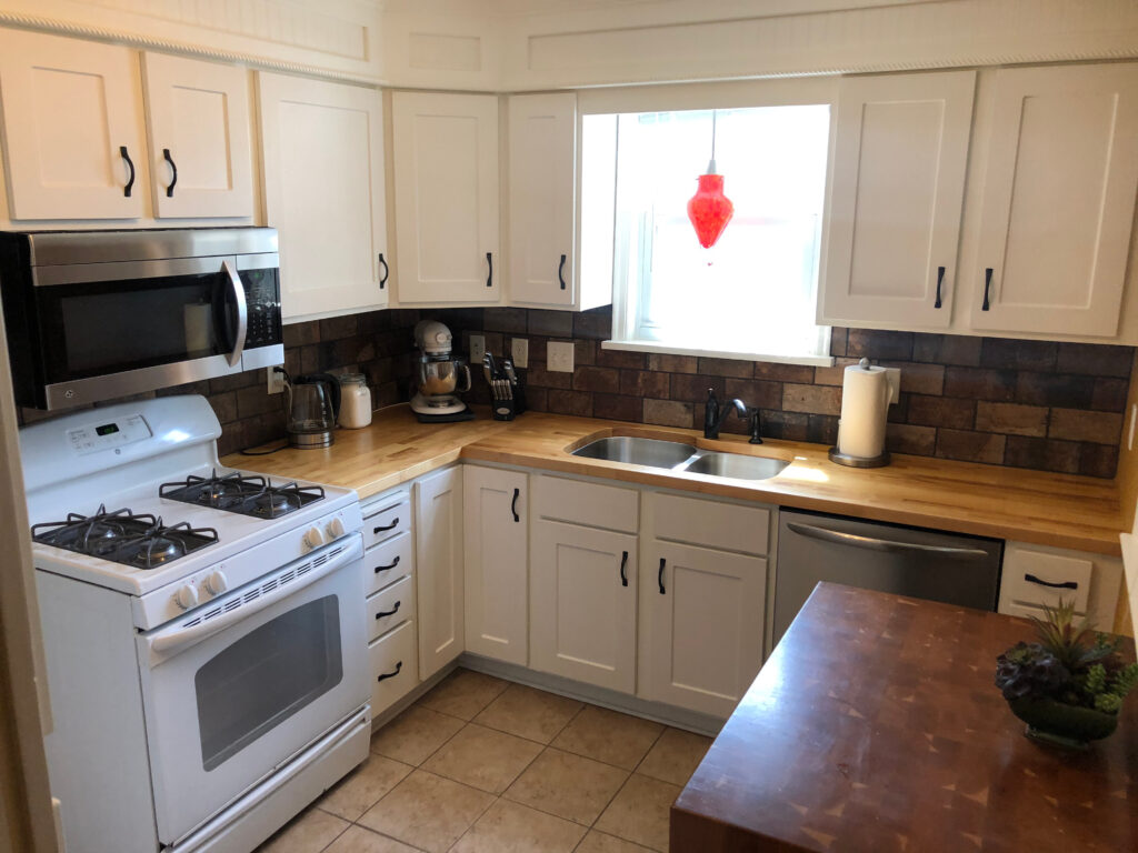 Soft neutral kitchen with Ranier White shaker cabinets and matte black pulls