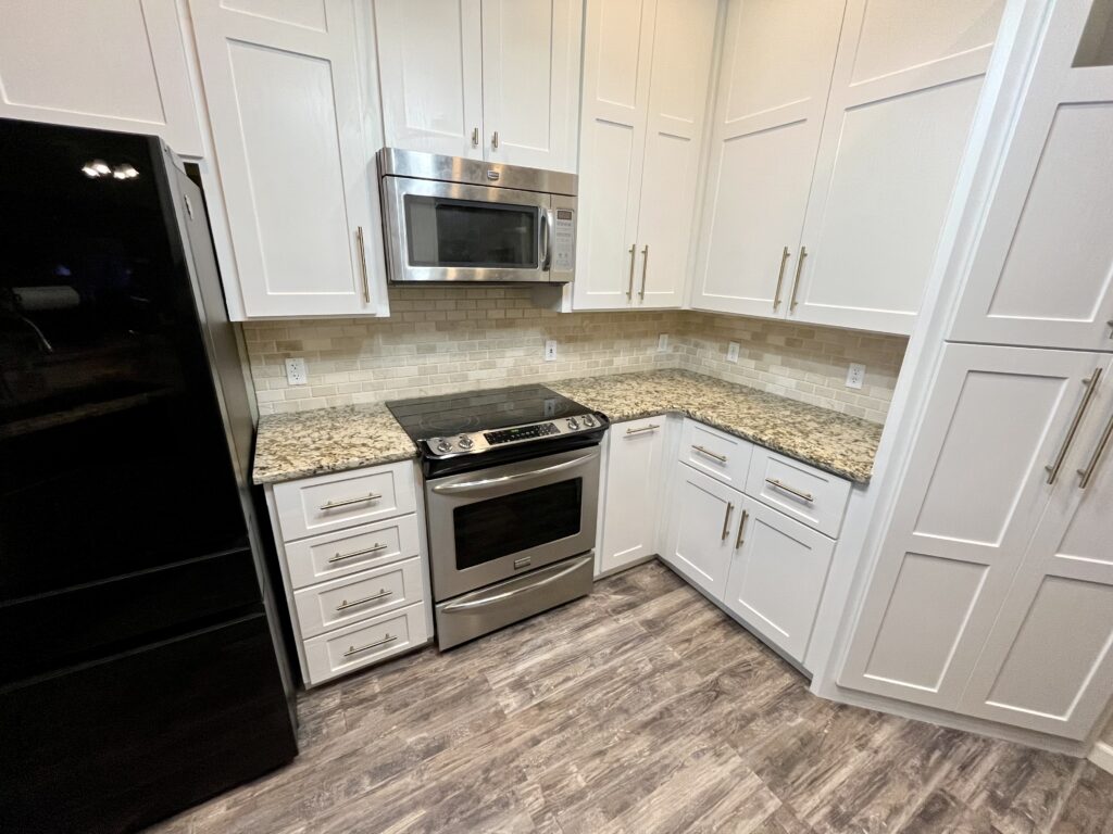 Completed Kitchen Refresh with white Shaker doors and drawer fronts, brushed nickel hardware, and stainless appliances