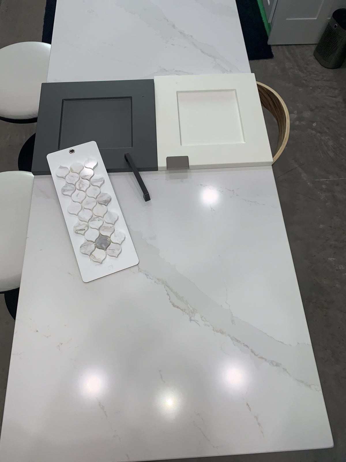 Thermofoil cabinet door samples in white and charcoal with hardware and tile at a Kitchen Refresh design consultation