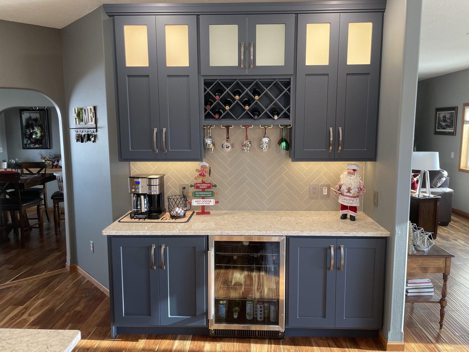 Navy thermofoil cabinet doors on a kitchen coffee bar with glass uppers and a wine rack